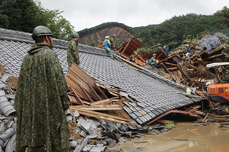 Rescue workers and Japan Self-Defense Force soldiers search for missing people amongst a destroyed house caused by flood waters in Tanabe, Wakayama prefecture, in western Japan. (JIJI PRESS/AFP/Getty Images)