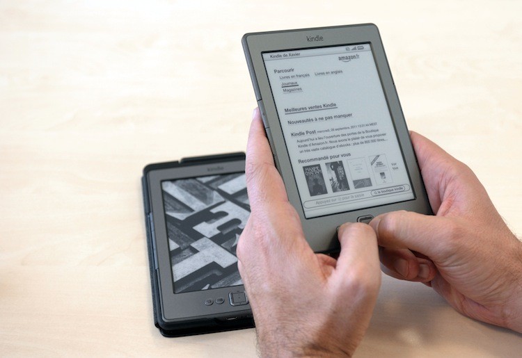 A person uses an Amazon Kindle electronic book reader. Thursday, Amazon announced a new subscription service that will allow Kindle owners to borrow books up to month for a flat annual fee. (Eric Piermont/Getty Images )