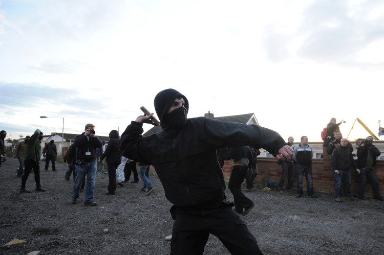A protester throws a piece of wood at police officers at the Dale Farm travelers site near Basildon in Essex, on October 19, 2011.  (Carl Court/AFP/Getty Images)