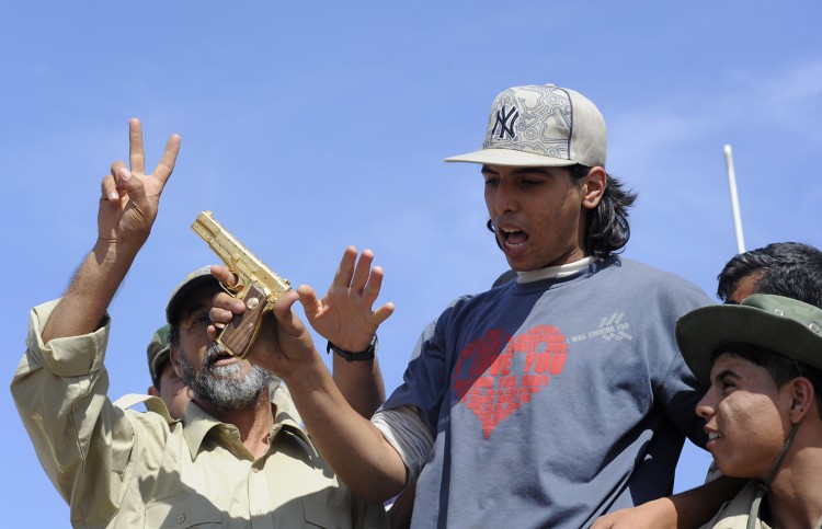 The Libyan National Transitional Council (NTC) fighter claimed to have found Gadhafi holds the gold-plated gun of the ousted Libyan leader. (PHILIPPE DESMAZES/AFP/Getty Images)