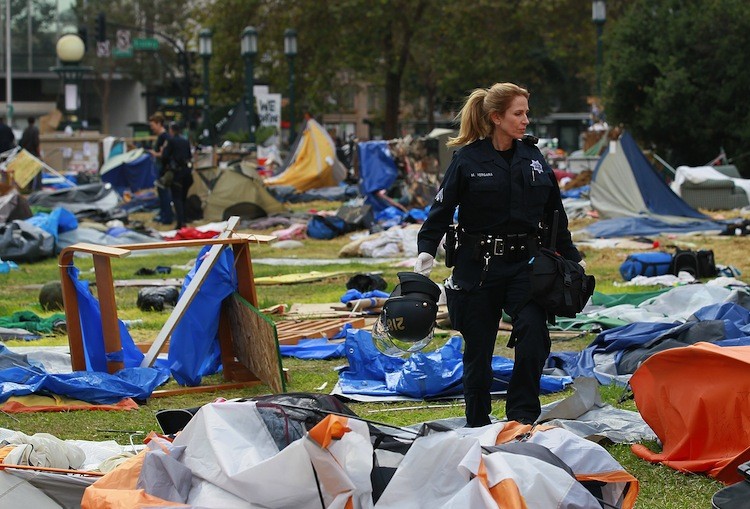 An Oakland police officer walks through the remains of the Occupy Oakland camp on Oct. 25 in Calif. Oakland police with other police agencies shut down the two-week-old camp that city officials said was a hazard.  (Justin Sullivan/Getty Images)
