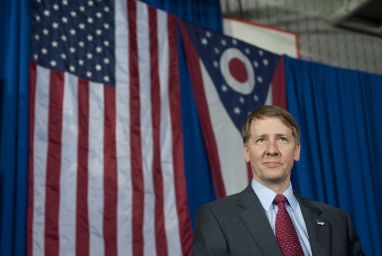 In this file photo, Richard Cordray, incoming head of the Consumer Financial Protection Bureau, stands offstage after President Barack Obama spoke in Shaker Heights, Ohio on Jan. 4