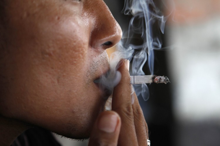 A man exhales smoke from his cigarette