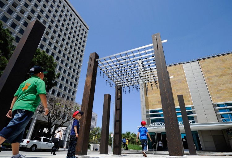 Children walk under an art installation outside the new LAPD Metropolitan Detention Center.