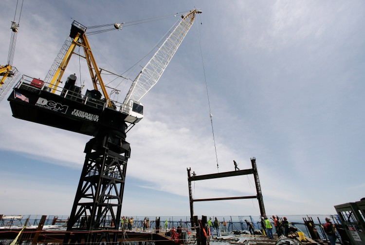A crane on the top deck of One world Trade Center holds a steel beam between two columns to make the tower New York City's tallest skyscraper, on April 30, 2012 in New York City. (Mark Lennihan-Pool/Getty Images)