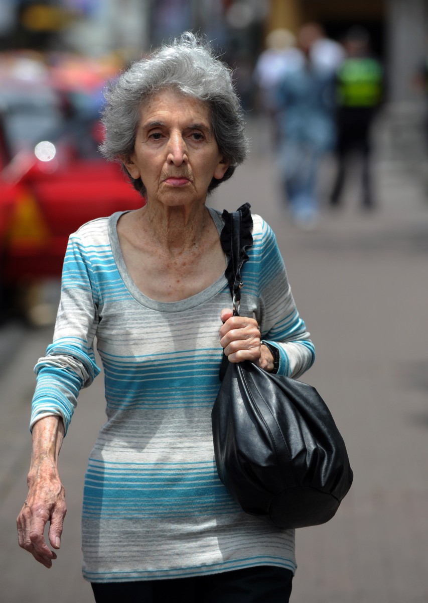 An elderly woman walks in San Jose