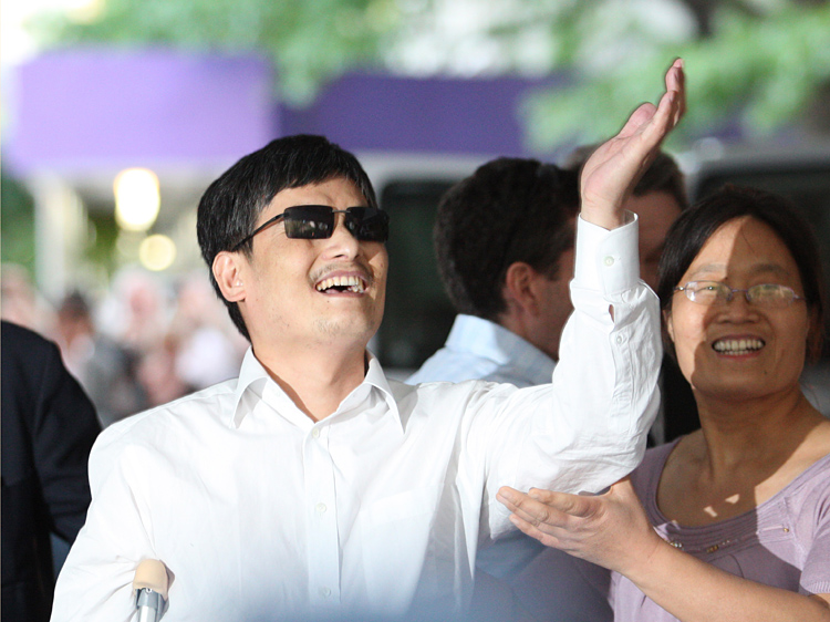 Chen Guangcheng gestures before making remarks to the media