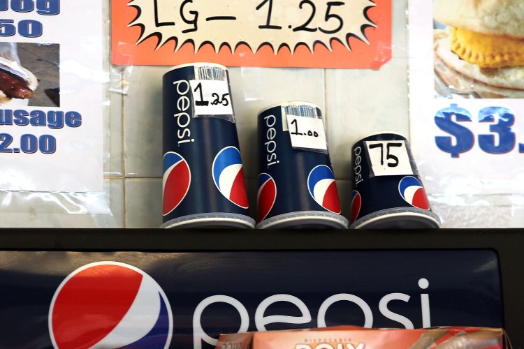 Various sizes of soft drink cups sit on a beverage dispenser in a fast food restaurant on June 1