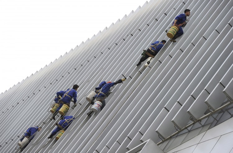 Workers clean the facade of a building i