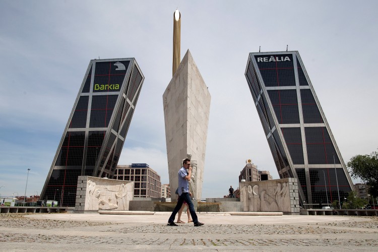 A man walks near the Kio Towers, headquarters of Spanish banking giant Bankia in Plaza de Castilla
