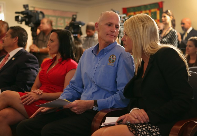 Florida Gov. Rick Scott speaks with Attorney General Pam Bondi during a bill signing ceremony