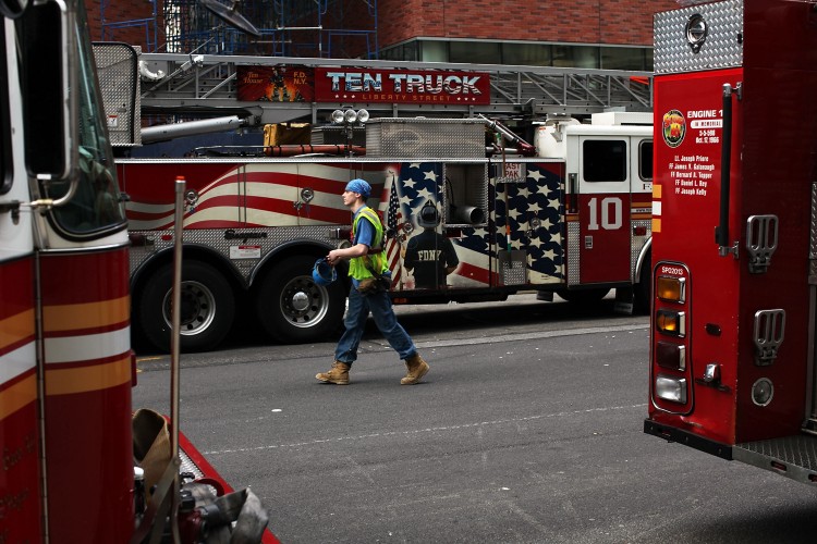 A Ground Zero construction worker walks by fire trucks