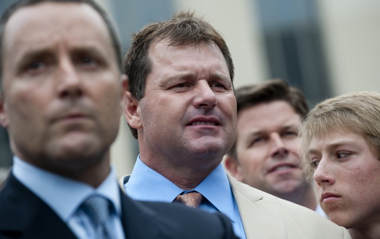 Former Major League Baseball pitcher Roger Clemens (2nd L) waits to speak to the media