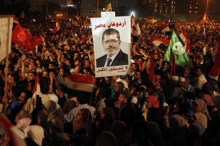 Thousands of Egyptian supporters of Muslim Brotherhood presidential candidate Mohammed Mursi (portrait) gather in Cairo's Tahrir Square on June 19, 2012. (Patrick Baz/AFP/GettyImages)