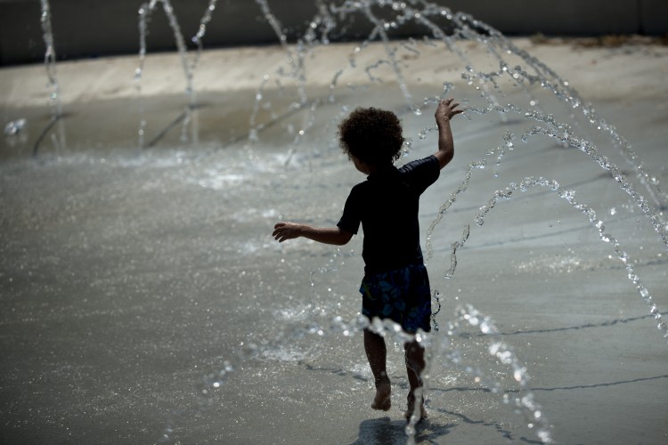 A boy plays in a water fountain at Wheatley Recreation Center