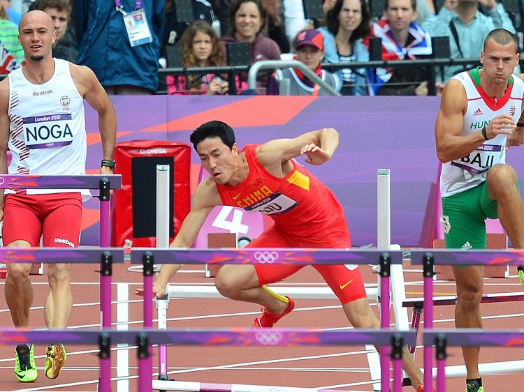 China's Liu Xiang (C) falls at the preliminaries