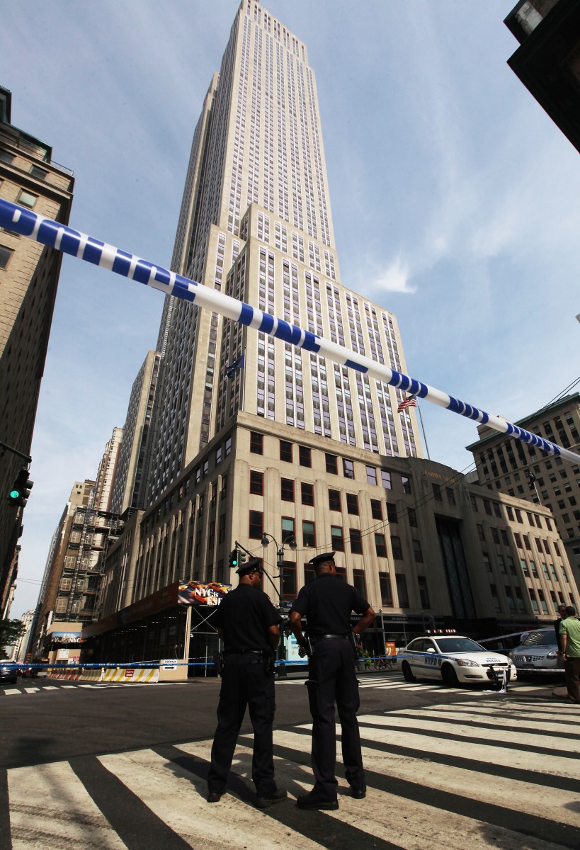 New York City police officers stand near the scene of a shooting near the Empire State Building on Friday, August 24 where Jeffrey Johnson shot and killed Steven Ercolino before police killed Ercolino. Nine bystanders were wounded in the incident, all from police bullets. (Mario Tama/Getty Images) 