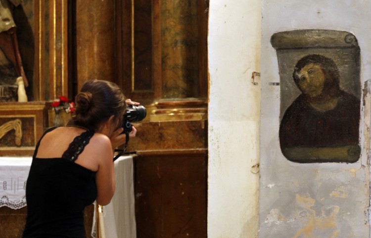 A woman takes pictures of the deteriorated version of a 