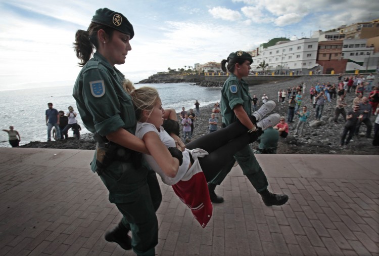 Spanish Guardia Civil members evict a woman from her home in the fishing village of Chovito on the Spanish Canary Island of Tenerife, on Nov. 16, 2012. (Desiree Martin/AFP/Getty Images)