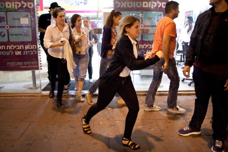 Israelis run for cover during a rocket attack 