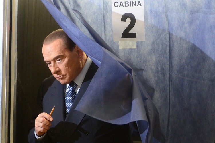 Italian former Prime Minister Silvio Berlusconi leaves the voting booth before casting his ballot at a polling station on Feb. 24, 2013 in Milan.  (Olivier Morin/AFP/Getty Images)