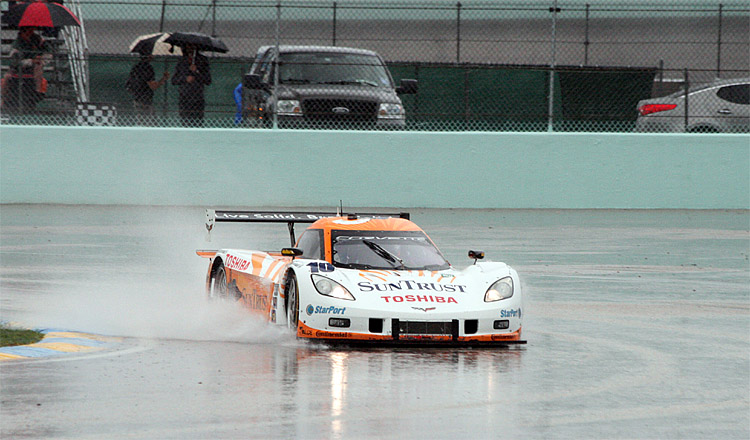 The No. 10 SunTrust Dallara-Corvette kicks up a wave as it passes through puddles on Homestead-Miami Speedway during the Rolex Grand Prix of Miami. (Chris Jasurek/The Epoch Times)