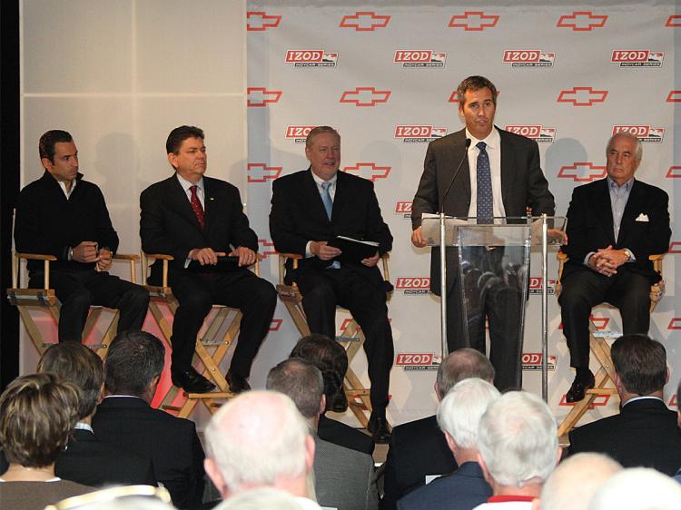 CHEVROLET MOTORS FOR INDYCAR: IndyCar CEO Randy Bernard (at podium) speaks as (L-R) driver Helio Castroneves, Chris Perry, vice president of Chevrolet Marketing Tom Stephens, GM vice chairman of Global Product Operations, IndyCar CEO Randy Bernard, and team owner Roger Penske listen at the IndyCar/Chevrolet press conference. (IndyCar.com)