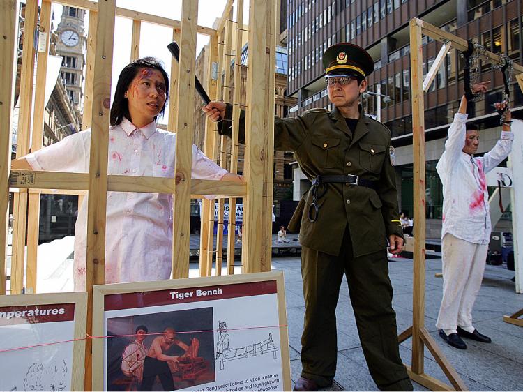 Falun Gong members re-enact Chinese torture methods used on their practitioners during a demonstration in Sydney. According to the Chinese regime, such torture is completely legal. (Torsten Blackwood/AFP/Getty Images)