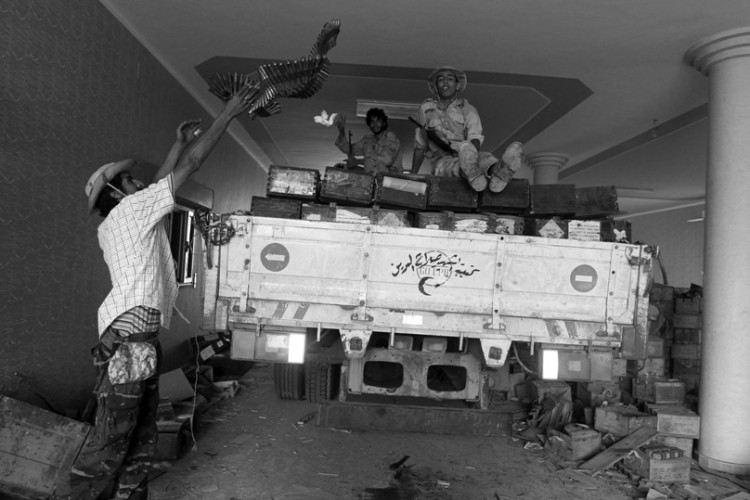 Libyan National Transitional Council (NTC) fighters load a truck with weapons after finding a cache inside a house in the village of Qasr Abu Hadi, the birthplace of Moammar Gadhafi. (Ahmad Al-Rubaye/Afp/Getty Images)