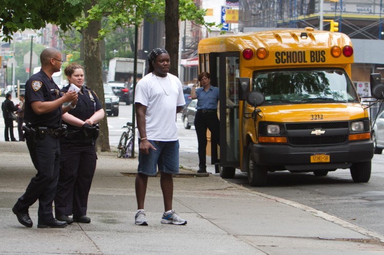 The custodian at the Meyer London PS 2 who was shot with a BB gun, waits next to police officers for an ambulance to come and examine him on May 23. (Benjamin Chasteen/The Epoch Times) 