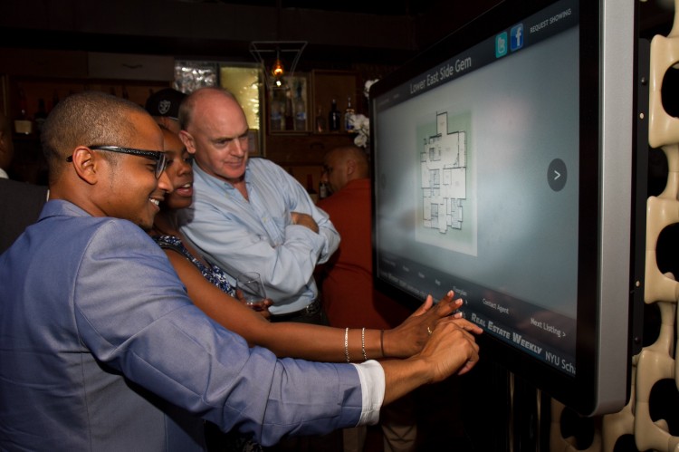 Vernon Jones, CEO of LOH, demonstrates to guests his company's new interactive touch screen on June 28. The touch screen is designed for real estate companies or brokers to install in storefront windows in the Lower East Side of Manhattan. (Benjamin Chasteen/The Epoch Times)