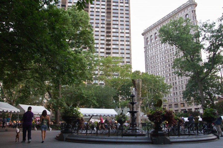 The fountain at Madison Square Park with the Flatiron building in the foreground in Manhattan on July 16