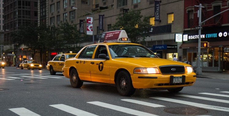 A New York City taxi with the new logo on the side of the car drives up Sixth Avenue in Midtown Manhattan on Sept. 3