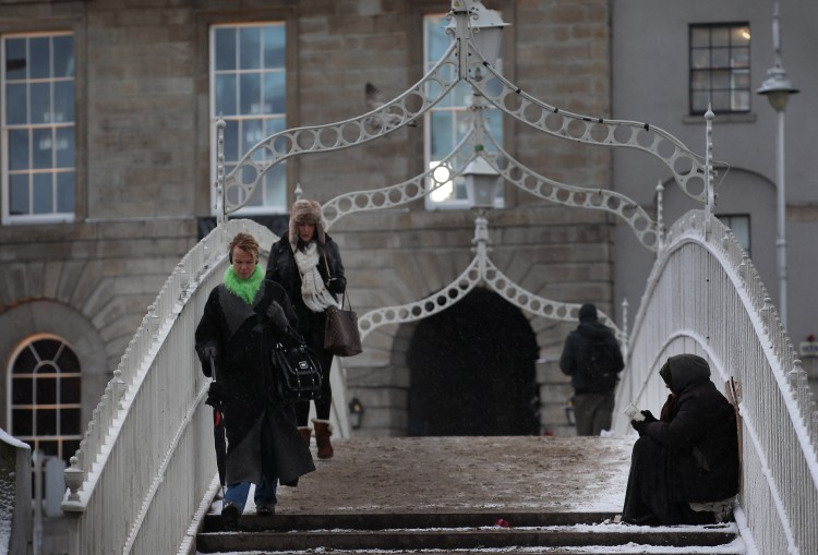 WHO'S IN HER CORNER?: A homeless woman holds out a cup for money on The Ha'Penny Bridge on December 1st, 2010 in Dublin, Ireland. In a poll, 78 per cent of Irish people wanted the right to adequate housing enshrined in the constitution