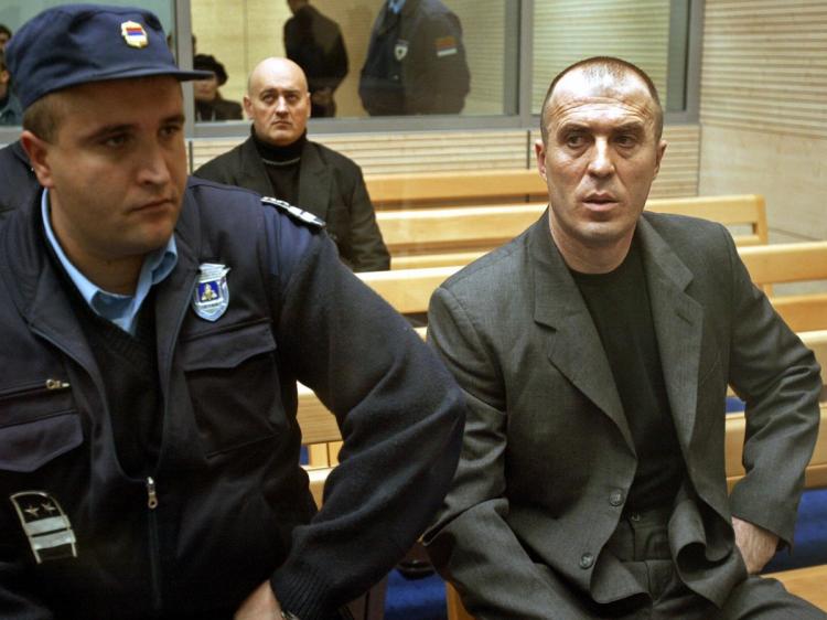 Police guarding prime suspect Zvezdan Jovanovic in Courtroom Number One of the Special Court for Trials Against Organized Crime in Belgrade December 22, 2003.  (Koca Sulejmanovic/AFP/Getty Images)