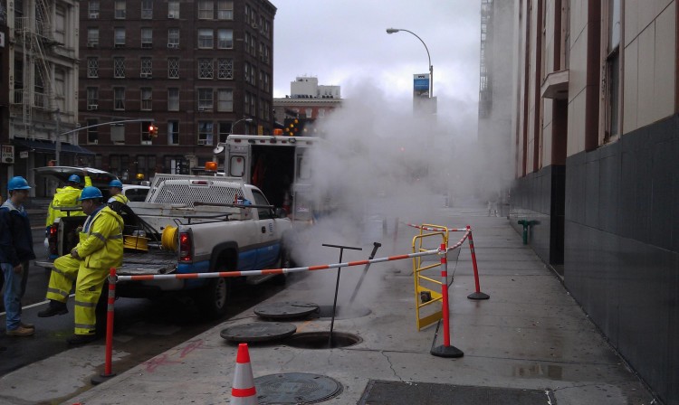 Workers let out subway steam on Canal Street and Wooster Street in Lower Manhattan. The steam was formed as a result of underground flooding. (Zack Stieber/The Epoch Times)