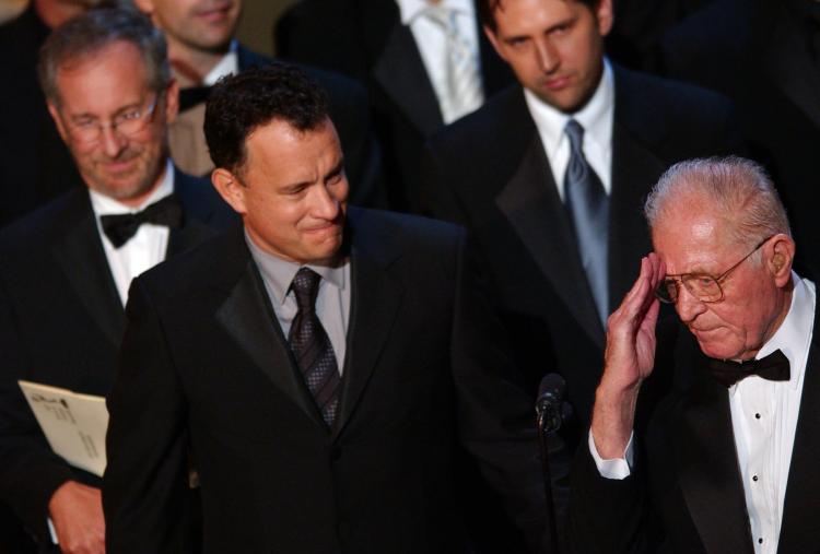 Steven Spielberg (L back) and Tom Hanks (C) watch Maj. Richard D. Winters (R) gives thanks for the Emmy awarded to 'Band Of Brothers' at the 54th Annual Primetime Emmy Awards, in Los Angeles, Sept. 22, 2002. (Lucy Nicholson/AFP/Getty Images)