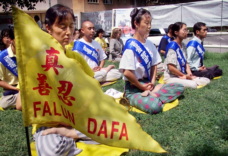 Falun Gong practitioners meditate as they enter the fourth day of a hunger strike