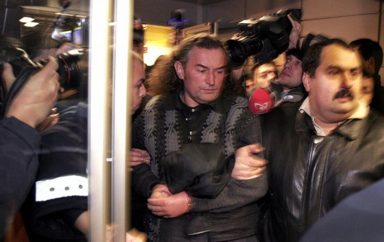 Former Romanian miners' leader Miron Cozma (C) is escorted by policemen after he was arrested in Timisoara, some 550 kms west of Bucharest, December 17, 2004.  (Petrut Calinescu/AFP/Getty Images)
