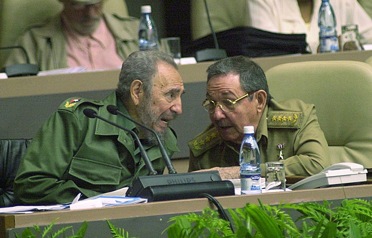 Cuban President Fidel Castro (L) talks to his brother Raul Castro (R) during the Cuban Parliament's session in the Palacio of the Conventions December 23, 2004 in Havana, Cuba. (Jorge Rey/Getty Images)