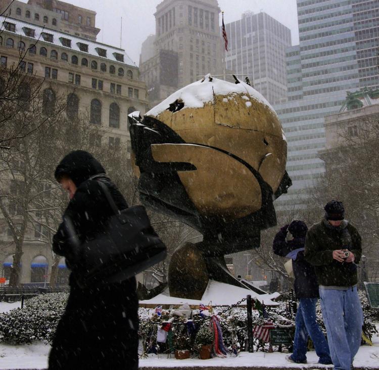 Visitors walk in heavy snow past 'The Sphere,' a sculpture by German architect Fritz Koenig, which survived the fatal terrorist attacks on 9/11 in Battery Park in lower Manhattan, in New York City. (Mandel NGAN/Getty Images)