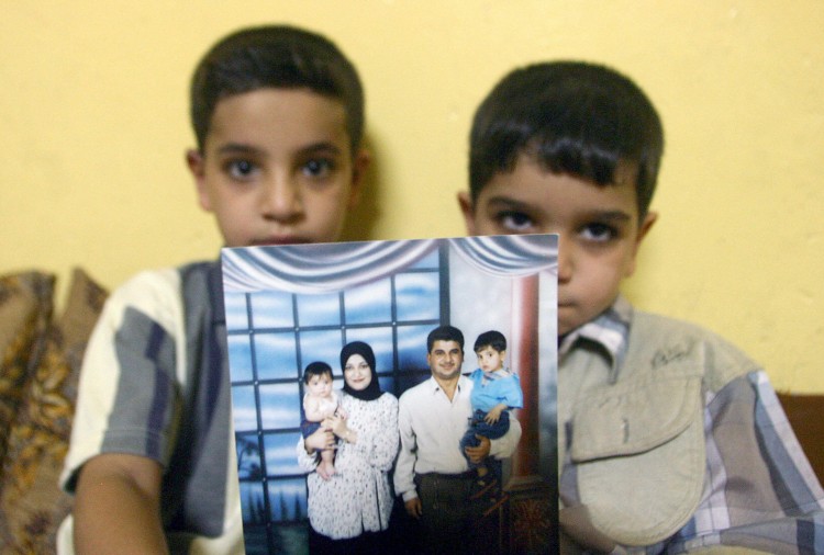 Hassan (L) sits with his younger brother Ali as they show off a family photo at their home in Basra, Iraq. The two boys are the sons of Baha Mousa.  (Essam al-Sudani/AFP/Getty Images)
