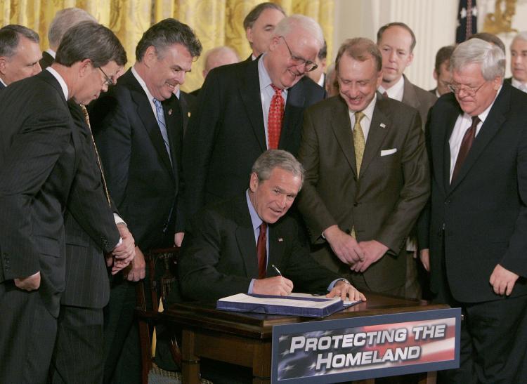 TOUGH ACT TO FOLLOW: Surrounded by members of Congress and Cabinet members, then President George W. Bush signs The USA PATRIOT and Terrorism Prevention Re-authorization Act of 2005. The Act had come under criticism from some in Congress for the potential to infringe of civil liberties but was pushed by the Bush administration as essential for fighting terrorism.   (Mark Wilson/Getty Images)