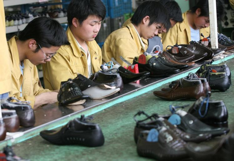 Factory workers check shoes for flaws on a production line at the Kangnai shoe factory in the Chinese city of Wenzhou. (Mark Ralston/AFP/Getty Images)