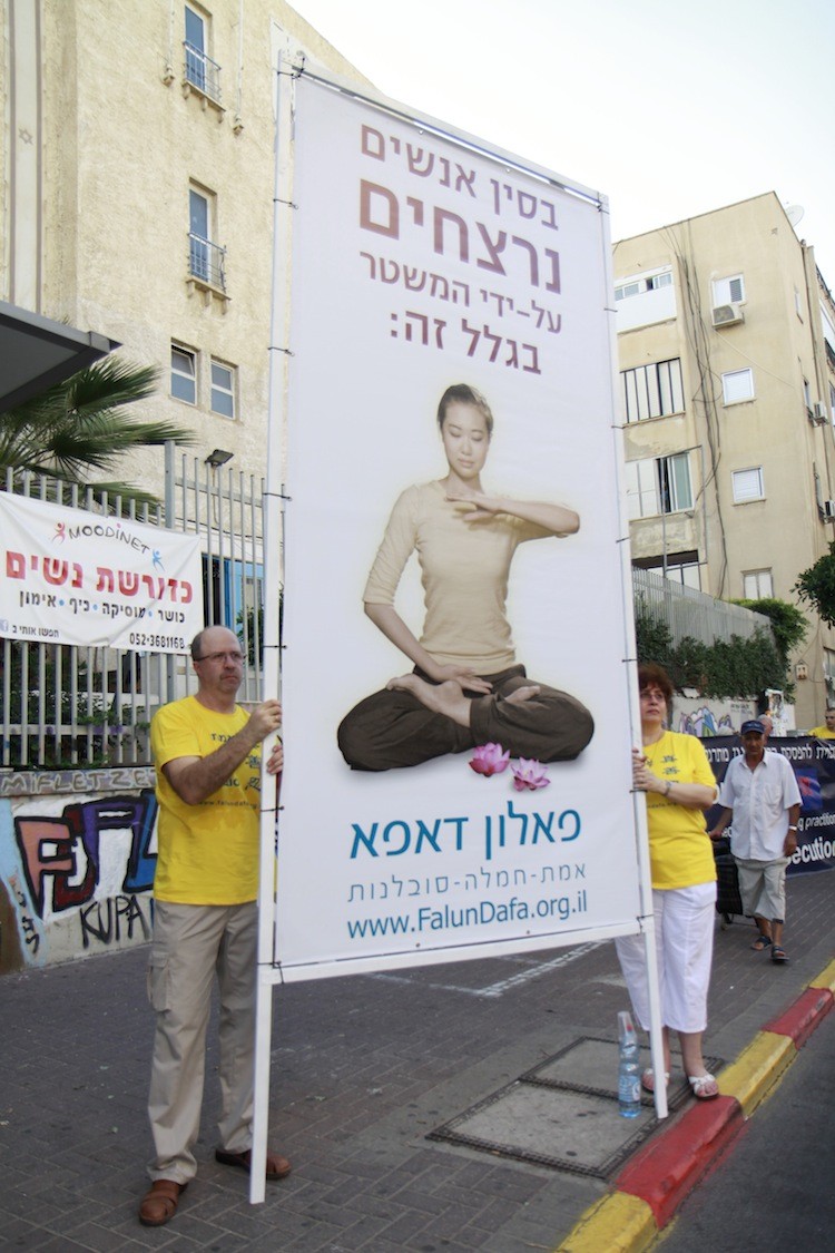 Participants hold a banner that reads: 'In China people are being murdered for doing this.'  (Tikva Mahabad /The Epoch Times)