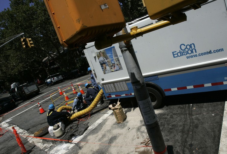 Technicians with Con Edison work on restoring power