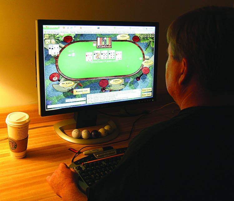 A man plays poker on his computer connected to an Internet gaming site from his home. A University of Calgary study found that online gambling is fuelling addiction rates in Canada. (Karen Bleier/AFP/Getty images)