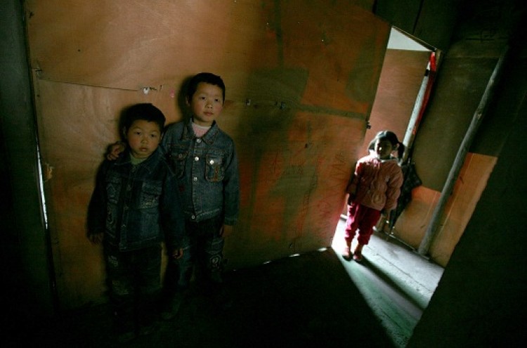 China's Vulnerable 'Left-behind Children:' Chen Xi (L), Chen Zhou (C), and Liang Xiaoyan, who all live with their grandmothers, plays at a house on March 5, 2007 in Chongqing, China. (China Photos/Getty Images)