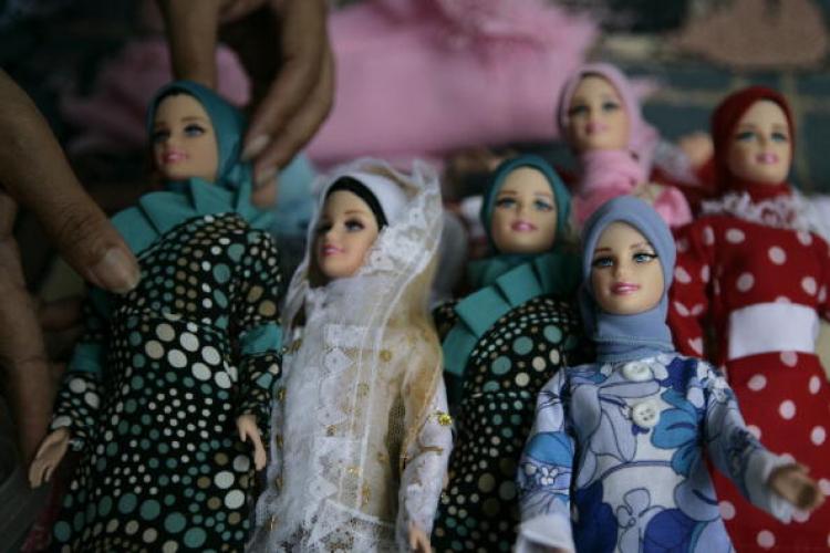 A woman dresses and assembles packaging of 'Arrosa' dolls on July 12, 2007 in Depok, West Java, Indonesia. (Dimas Ardian/Getty Images)