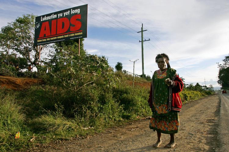 A woman walks past a anti-AIDS billboard in Mount Hagen. (Anoek De Groot/AFP/Getty Images)